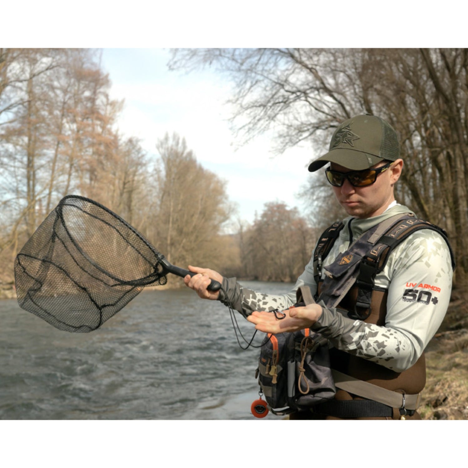 Delphin SHORX landing net in use on a river during wading fishing