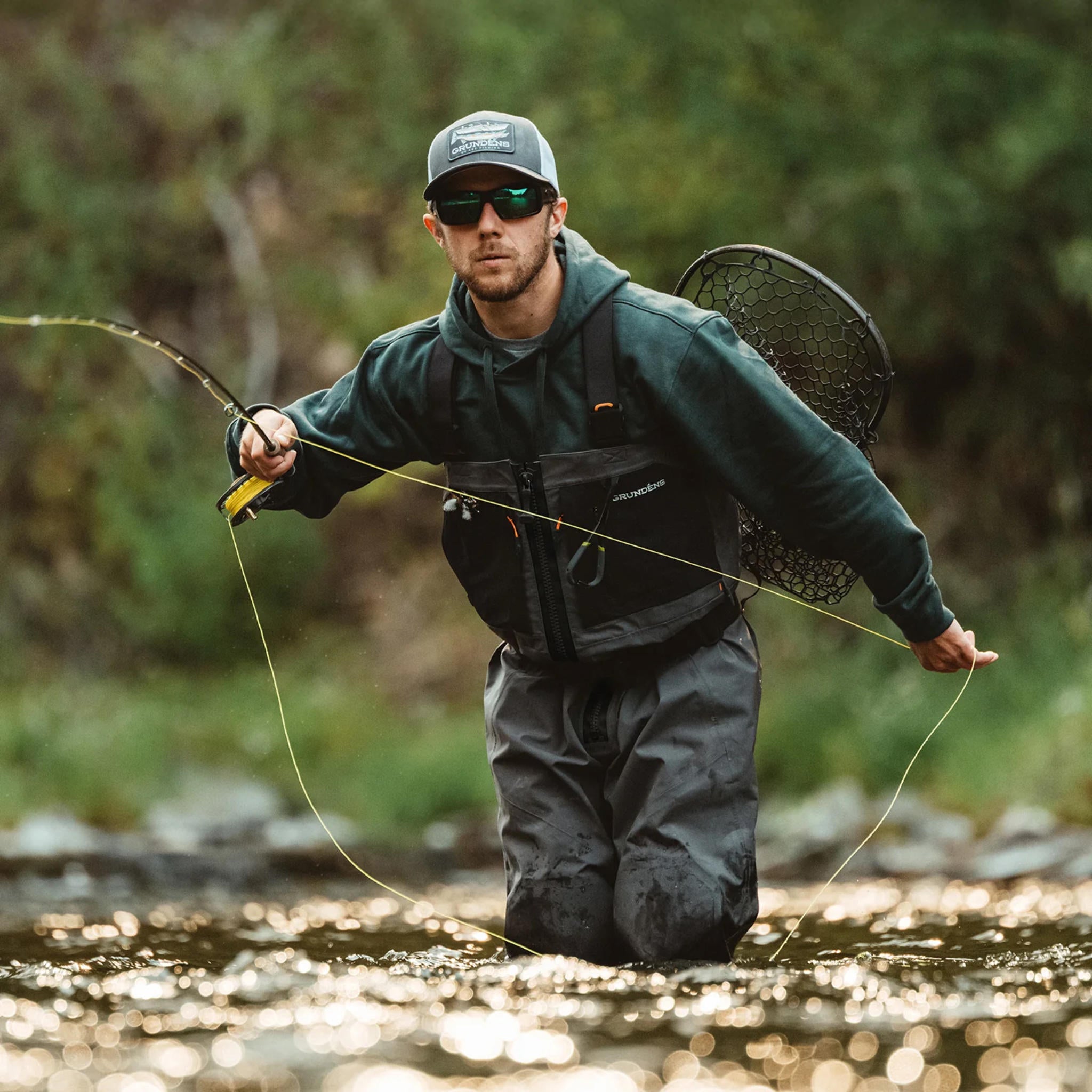 Fly fisherman wading in river wearing Grundéns Vector Zip Wader in real use