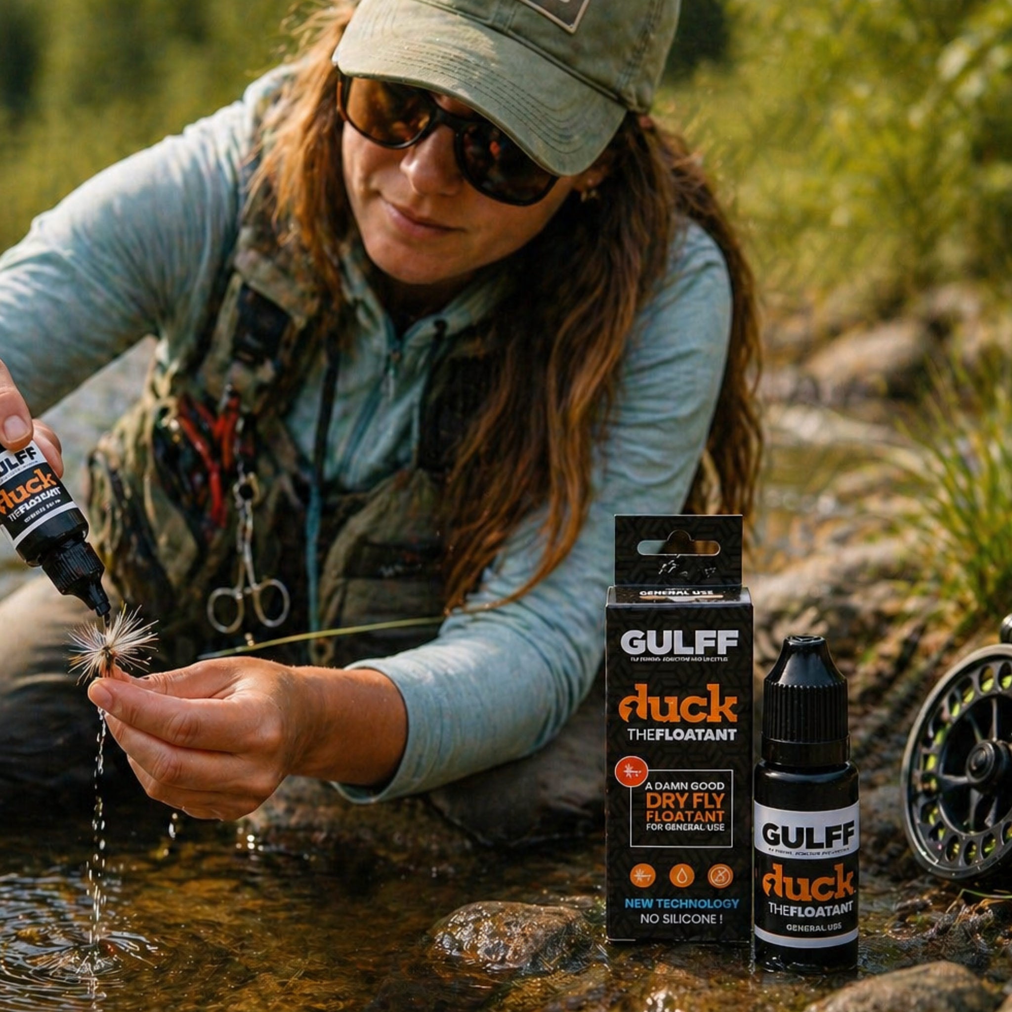 Female fly angler applying Gulff Duck The Floatant to a dry fly by the river