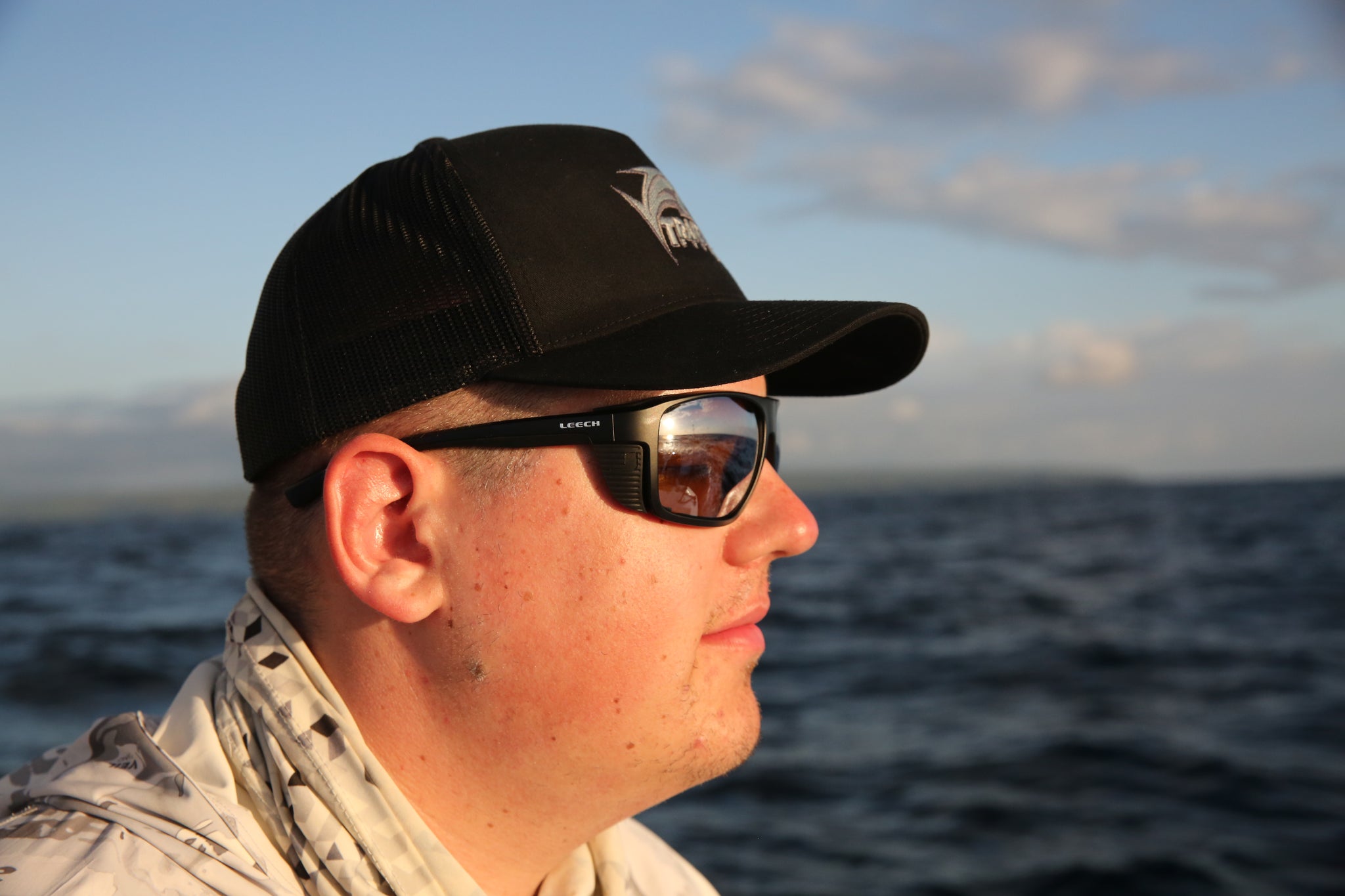 Angler wearing Leech X FishPro Fire polarized fishing sunglasses on open water