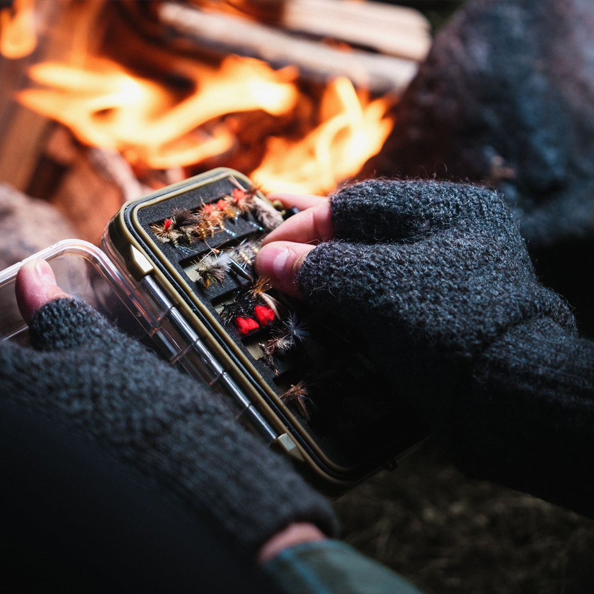 LOOP Fingerless Wool Gloves worn while selecting flies beside a campfire