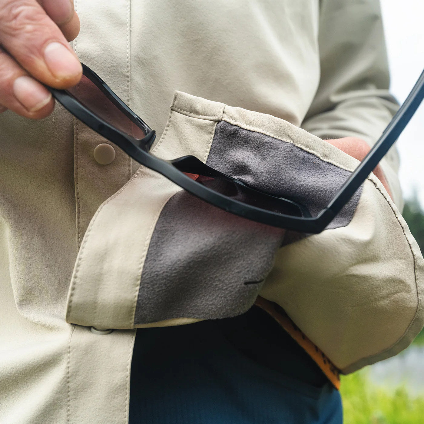 Cleaning polarized sunglasses with the built-in microfiber cloth on the RepYourWater Wellfleet shirt